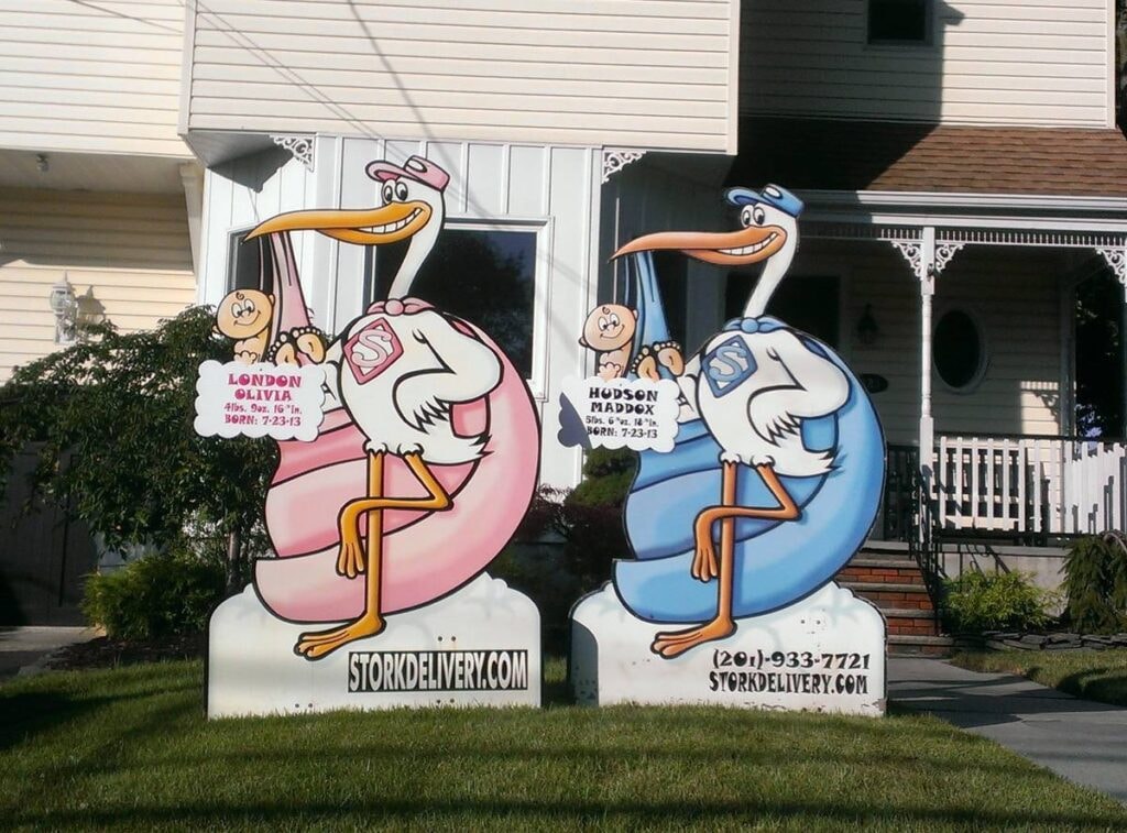 Two stork signs side by side announcing twin births